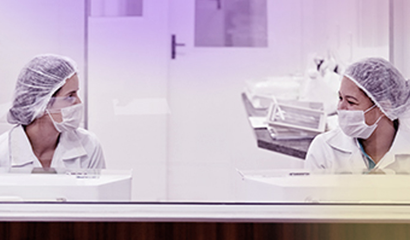 Δύο γυναίκες με στολή εργαστηρίου που εργάζονται στη Viatris